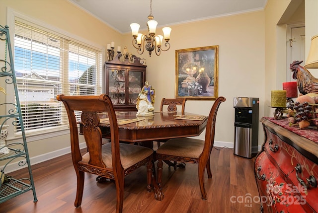 dining room featuring dark wood-style floors, an inviting chandelier, crown molding, and baseboards