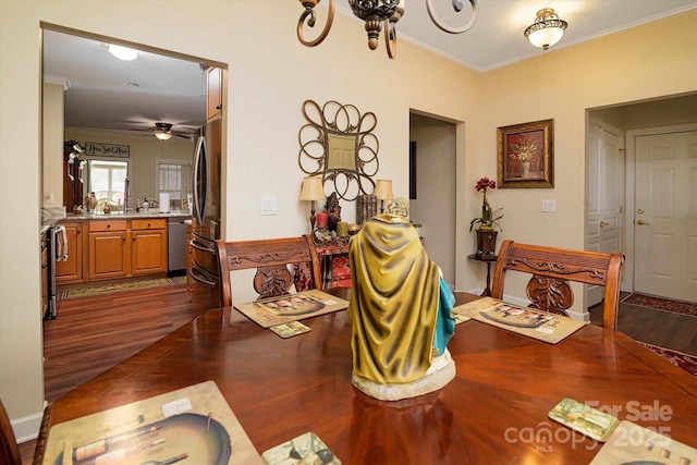 dining space with crown molding, ceiling fan, and dark wood-style flooring