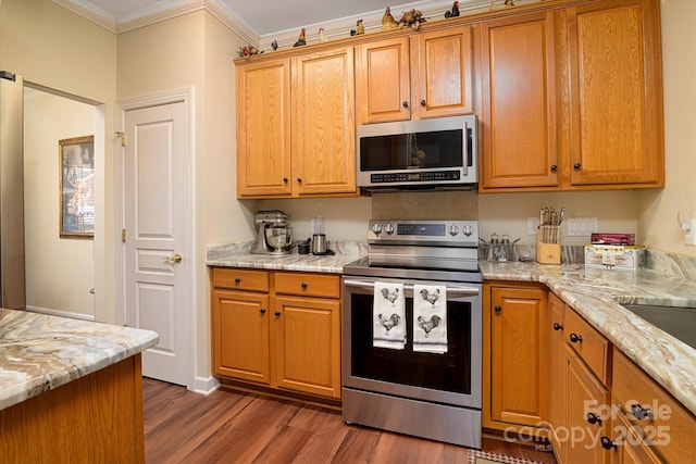 kitchen with dark wood-type flooring, light stone countertops, ornamental molding, brown cabinetry, and stainless steel appliances