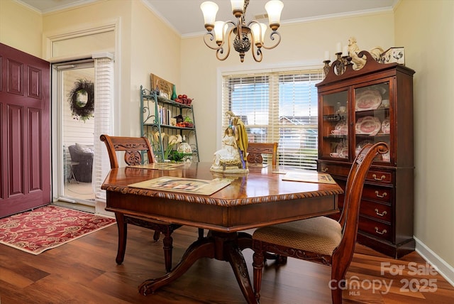 dining room with baseboards, crown molding, an inviting chandelier, and wood finished floors