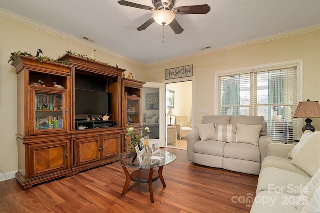 living area with visible vents, ornamental molding, and wood finished floors