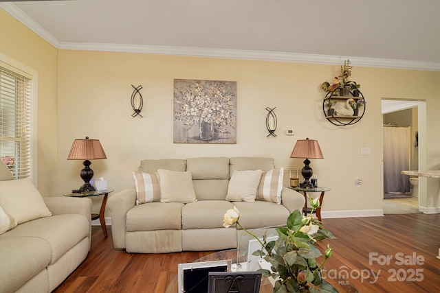 living area with baseboards, wood finished floors, and ornamental molding