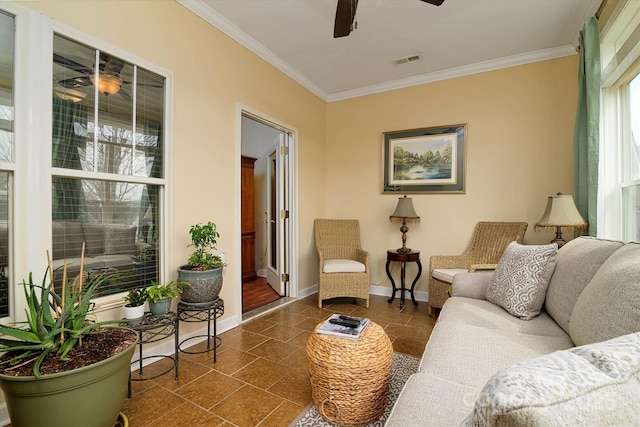 living room featuring stone tile floors, visible vents, baseboards, and ornamental molding