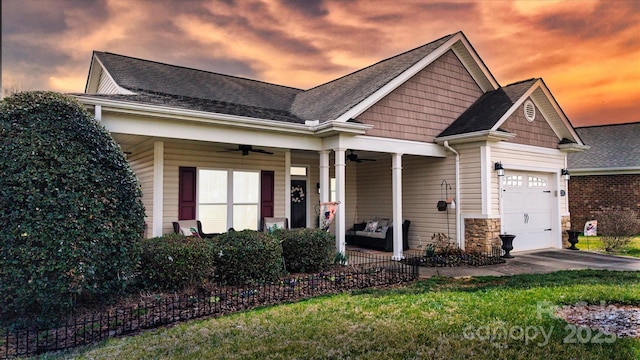 view of front of house featuring a ceiling fan, covered porch, a shingled roof, a garage, and stone siding