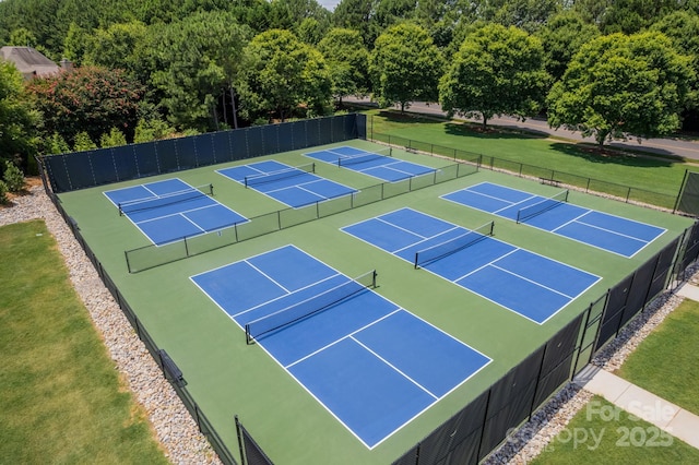 view of sport court with a lawn and fence