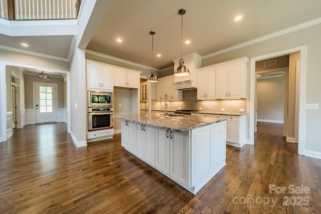 kitchen featuring appliances with stainless steel finishes, white cabinets, dark wood finished floors, and backsplash