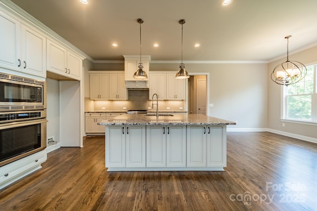 kitchen featuring crown molding, stainless steel appliances, decorative backsplash, a sink, and light stone countertops