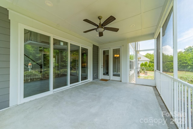 unfurnished sunroom featuring ceiling fan