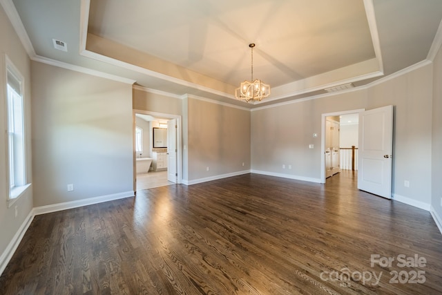 spare room featuring an inviting chandelier, visible vents, a tray ceiling, and dark wood-style flooring