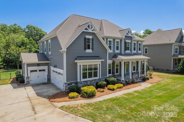 craftsman-style house with roof with shingles, a porch, concrete driveway, stone siding, and a front lawn