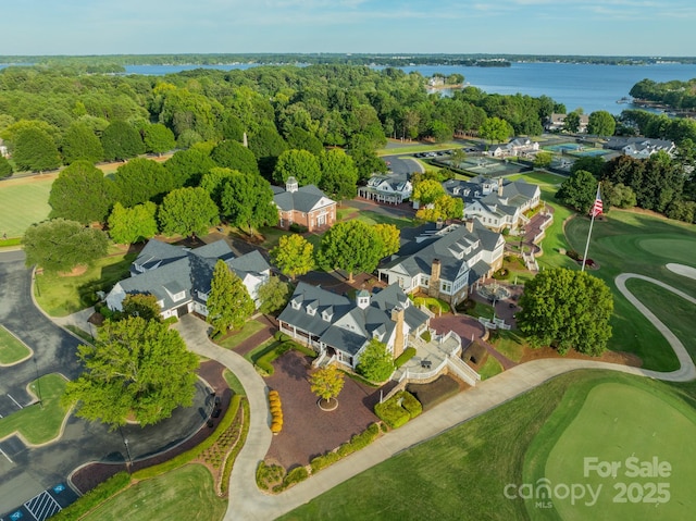 drone / aerial view featuring a residential view, a water view, and a view of trees