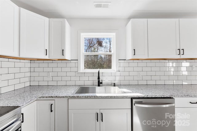 kitchen with visible vents, decorative backsplash, white cabinets, a sink, and dishwasher