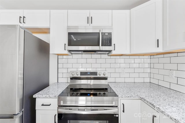 kitchen featuring stainless steel appliances, white cabinetry, and tasteful backsplash