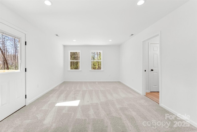 carpeted spare room featuring baseboards and recessed lighting