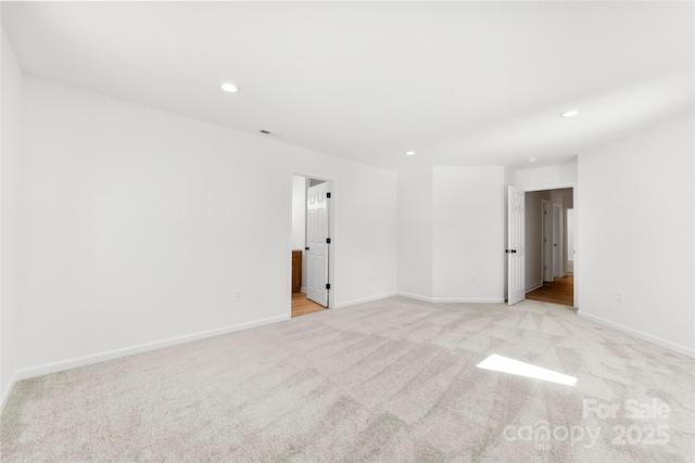 empty room with light carpet, baseboards, and recessed lighting