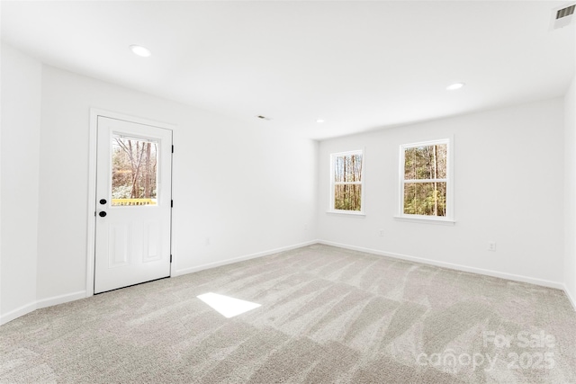 unfurnished room with carpet, visible vents, baseboards, and recessed lighting