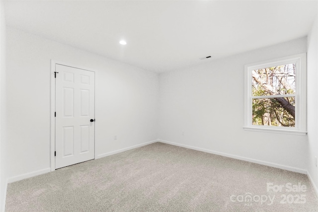 carpeted empty room featuring recessed lighting, visible vents, and baseboards