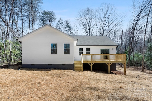 back of house featuring crawl space, a deck, and roof with shingles