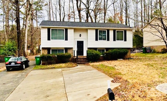 bi-level home featuring concrete driveway and brick siding