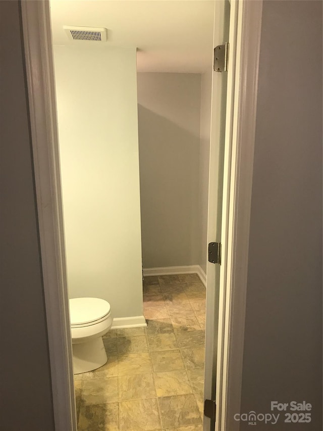 bathroom featuring visible vents, toilet, and baseboards