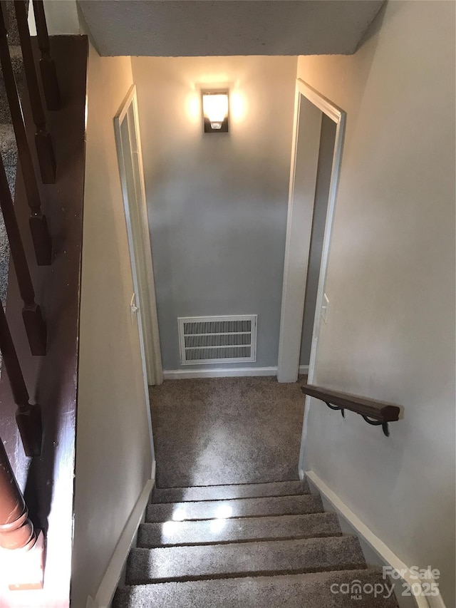 staircase with baseboards and visible vents