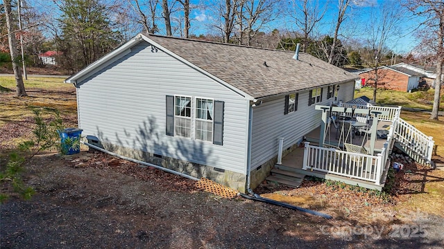 view of side of home with a deck, a shingled roof, and crawl space