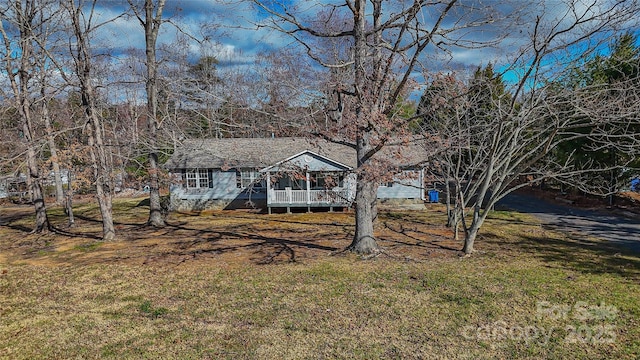 view of front facade with a deck and a front lawn