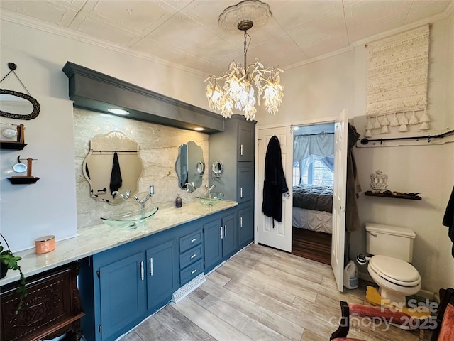 full bathroom featuring decorative backsplash, toilet, an ornate ceiling, wood finished floors, and crown molding