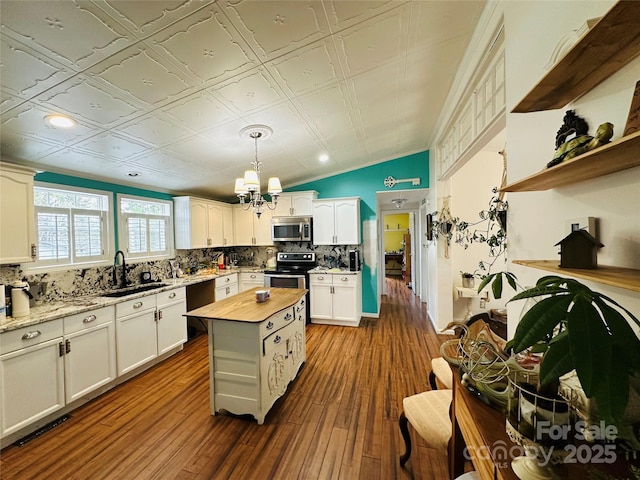 kitchen featuring tasteful backsplash, an ornate ceiling, butcher block counters, stainless steel appliances, and a sink