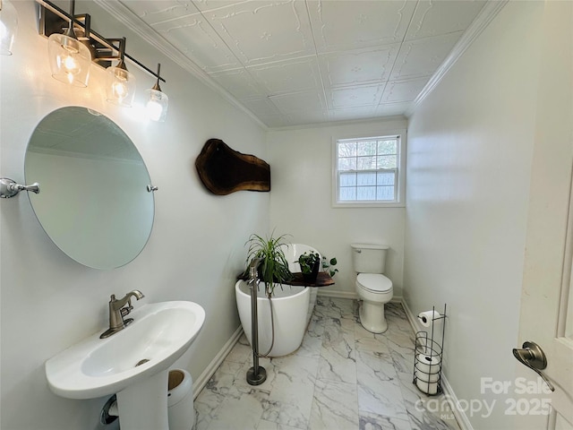 full bathroom with marble finish floor, crown molding, baseboards, and a freestanding bath