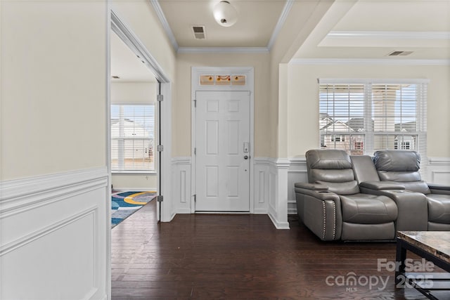 foyer entrance featuring a wainscoted wall and crown molding