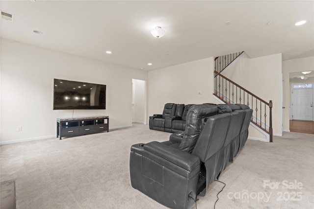 living area featuring stairway, light colored carpet, visible vents, and baseboards