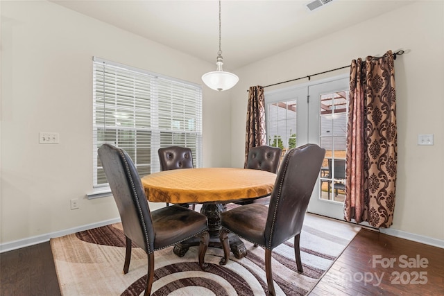 dining room featuring visible vents, baseboards, and hardwood / wood-style floors