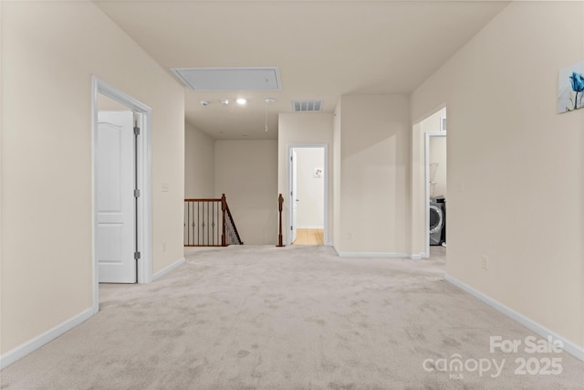 corridor with baseboards, carpet, attic access, an upstairs landing, and washer / dryer