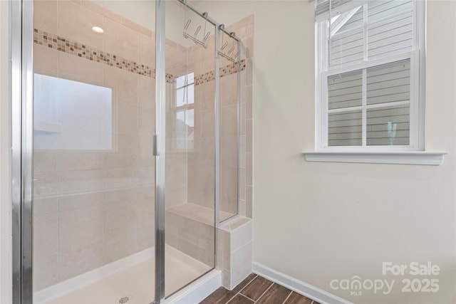 bathroom featuring a shower stall, wood finished floors, and baseboards