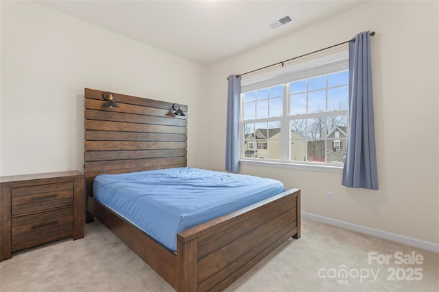 bedroom with visible vents, light carpet, and baseboards