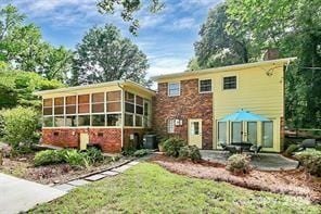 back of property with a sunroom and a patio area