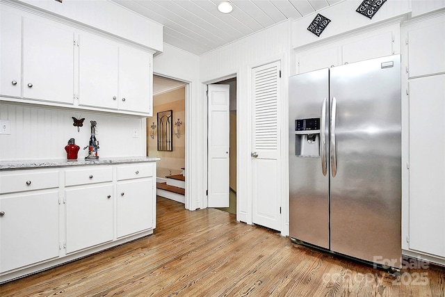 kitchen with light wood-style floors, white cabinetry, and stainless steel refrigerator with ice dispenser