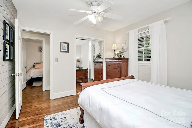 bedroom with ceiling fan, a closet, wood finished floors, and baseboards