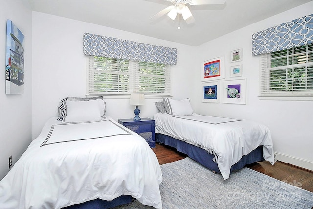 bedroom featuring ceiling fan, baseboards, and wood finished floors