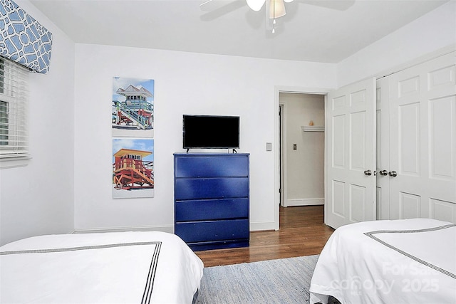 bedroom with baseboards, a closet, a ceiling fan, and wood finished floors