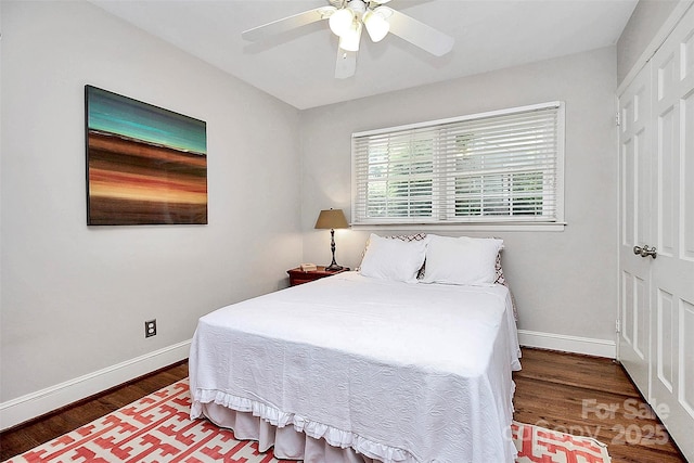 bedroom featuring a ceiling fan, a closet, baseboards, and wood finished floors