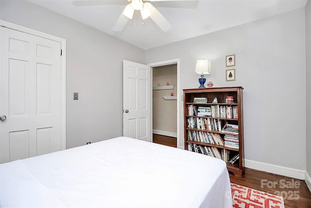 bedroom featuring a ceiling fan, baseboards, and wood finished floors