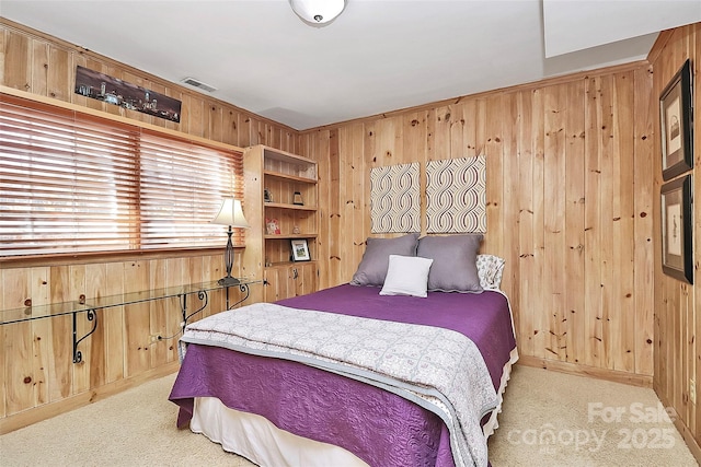 bedroom featuring carpet, wooden walls, and visible vents