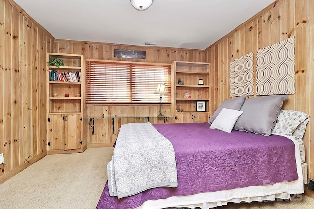 bedroom featuring wooden walls, visible vents, and carpet flooring