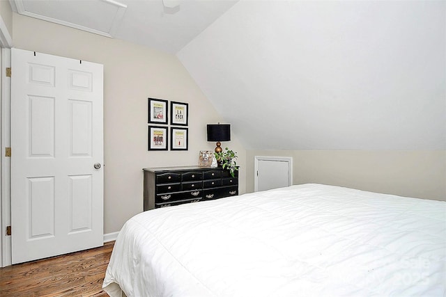 bedroom featuring attic access, lofted ceiling, and dark wood finished floors