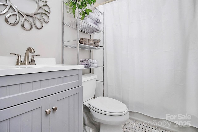 bathroom with toilet, curtained shower, and vanity