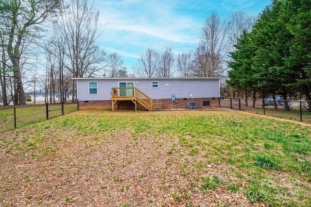 rear view of house with crawl space, a fenced backyard, and a lawn