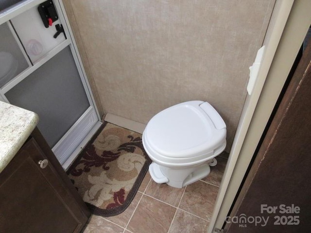 bathroom featuring tile patterned floors, toilet, and vanity