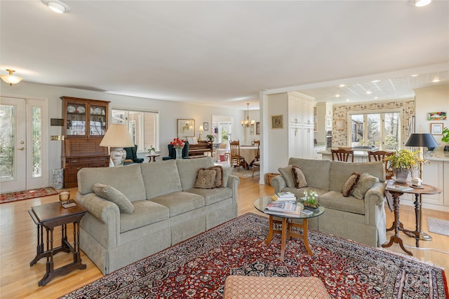 living area with light wood-style floors and an inviting chandelier